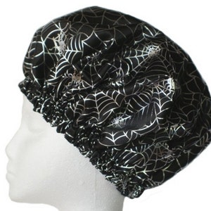 May include: Black satin shower cap with a silver spiderweb pattern.