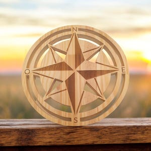 Peut inclure: Une rose des vents en bois de couleur marron clair, avec les points cardinaux (N, E, S, O) gravés. Le centre présente un motif en étoile. L'objet est de forme circulaire.