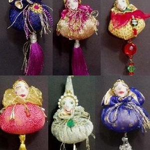 May include: Six handmade ornaments featuring whimsical characters with colorful fabric and embellishments. Each ornament has a unique design and features a different color scheme. The ornaments are perfect for adding a touch of whimsy to any Christmas tree or holiday decor.