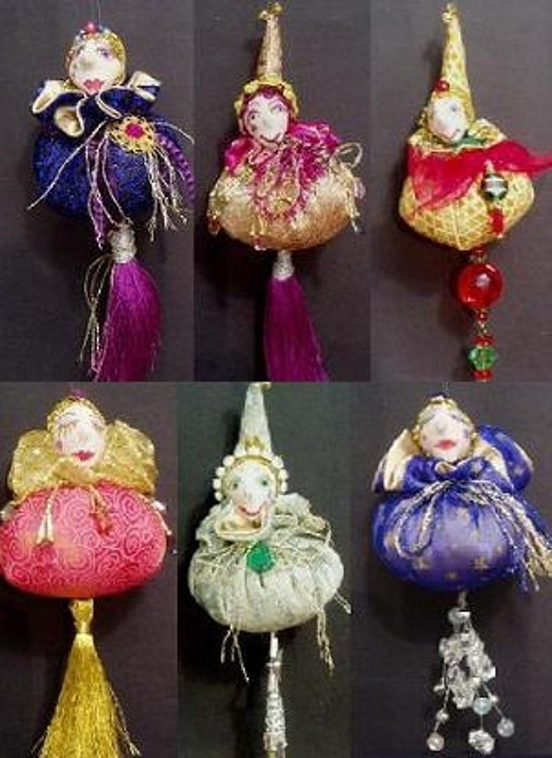 May include: Six handmade ornaments featuring whimsical characters with colorful fabric and embellishments. Each ornament has a unique design and features a different color scheme. The ornaments are perfect for adding a touch of whimsy to any Christmas tree or holiday decor.