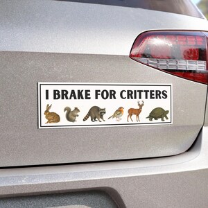 Puede incluir: Una pegatina rectangular para parachoques con el texto "I BRAKE FOR CRITTERS" en letras mayúsculas negras. Debajo del texto hay ilustraciones de un conejo, una ardilla, un mapache, un pájaro, un ciervo y una tortuga.