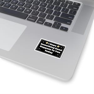 Pu&ograve; includere: Un adesivo rettangolare con sfondo nero e bordo bianco &egrave; posizionato su un laptop. L'adesivo riporta la scritta "I Hope Something Good Happens To You Today" in bianco, con decorazioni a margherita e stella.