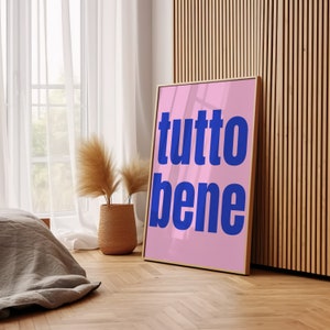 Könnte beinhalten: Ein rosa gerahmtes Poster mit den Worten "tutto bene" in blauer Schrift auf weißem Hintergrund.