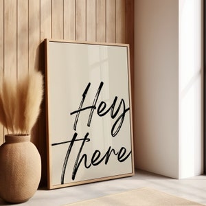Könnte beinhalten: Ein gerahmter Druck mit beigefarbenem Hintergrund und schwarzem Text, der "Hey there" lautet.