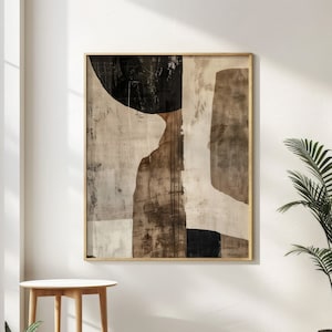K&ouml;nnte beinhalten: Abstrakter Kunstdruck mit braunen, schwarzen und wei&szlig;en geometrischen Formen auf einer strukturierten Leinwand. Der Druck ist in einem d&uuml;nnen, goldenen Rahmen gerahmt.