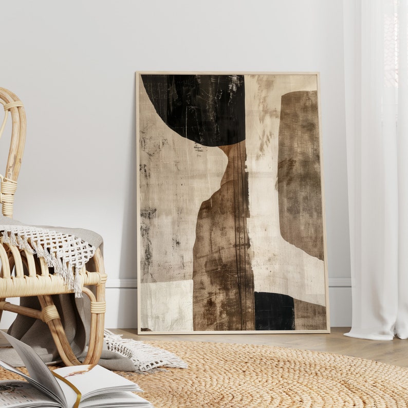 K&ouml;nnte beinhalten: Abstrakter Kunstdruck in einem Holzrahmen mit einem Farbschema in Beige, Braun und Schwarz. Der Druck zeigt geometrische Formen und Texturen.