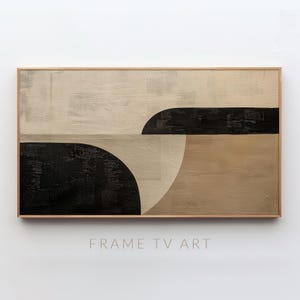 May include: Abstract art piece in a rectangular wooden frame. The artwork features a combination of beige, black, and tan colors. The design includes geometric shapes, such as semi-circles and horizontal lines. The text "FRAME TV ART" is at the bottom.