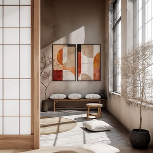May include: A serene interior scene featuring two framed abstract art pieces with geometric shapes in warm tones. A wooden bench with pillows, a small stool, and a potted plant add to the minimalist aesthetic. The room is bathed in natural light.