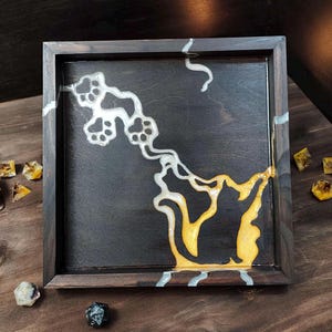 May include: A square wooden tray with a dark stained finish. The tray features a black background with a yellow cat silhouette and white paw prints. Several dice and a skull are scattered around the tray.