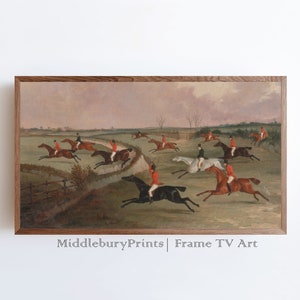 May include: A vintage painting depicting a group of riders on horseback in a field. The riders are wearing red jackets and are galloping across a grassy field with a fence in the background. The sky is a soft pink and blue.