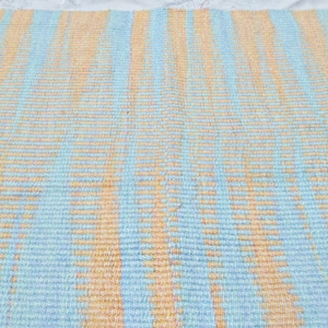 May include: A woven rug with alternating stripes of light blue and peach.