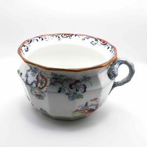 May include: A white ceramic mug with a black handle and the text "But First, Coffee" in a black, bold font. The mug is on a white surface.