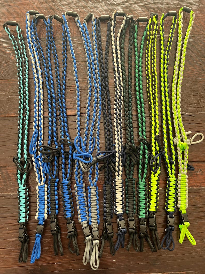 Puede incluir: Una colecci&oacute;n de 12 cordones trenzados en varias combinaciones de colores, incluyendo negro, azul, verde y blanco. Cada cord&oacute;n tiene un clip de pl&aacute;stico negro en el extremo.