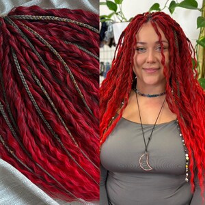 May include: Vibrant red dreadlocks with gray and gold accents. The dreadlocks are styled in a wavy pattern. The image shows a close-up of the dreadlocks and a person with the same style. The hair is long and flowing.