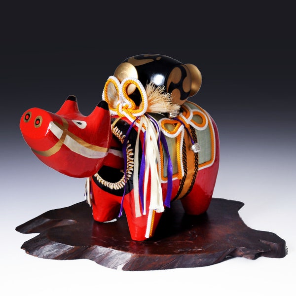 Grande figurine japonaise Akabeko ( vache rouge ) en papier mâché ( hariko) . Tête pivotante et divers accessoires sur son dos.