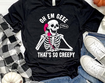 May include: Black t-shirt with a white skeleton graphic holding a pink telephone. The text on the shirt reads "OH EM GEEE THAT'S SO CREEPY" with a speech bubble saying "I LOVE IT".