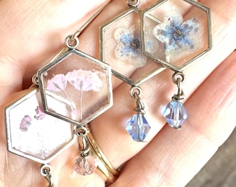 Brincos hexagonais prateados com flores naturais secas e prensadas, em resina. Flores típicas de terrário do noroeste do Pacífico, incluindo gipsofila rosa e miosótis azul.