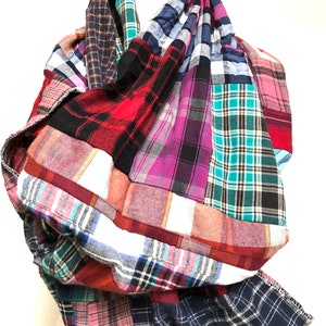 May include: A patchwork scarf made from different plaid fabrics in shades of red, blue, green, pink, and white.