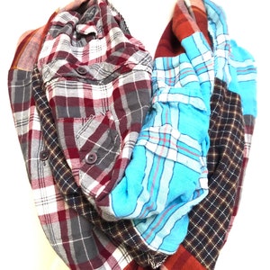 May include: A plaid scarf made from repurposed flannel shirts. The scarf features a variety of colors, including red, blue, gray, and brown.