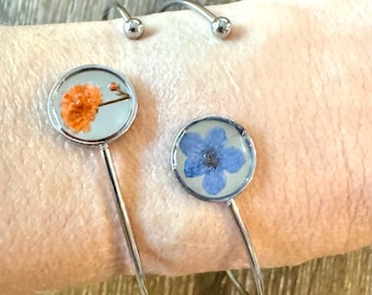 Pulseira rígida de prata com resina de flores naturais secas e prensadas, estilo terrário do noroeste do Pacífico, ajustável, nas cores azul e laranja, com miosótis e gipsófila.