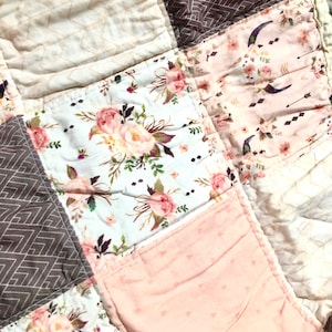 May include: A patchwork quilt with a floral pattern, geometric patterns, and a pink background. The quilt is made of different fabrics and has a rustic, vintage look.