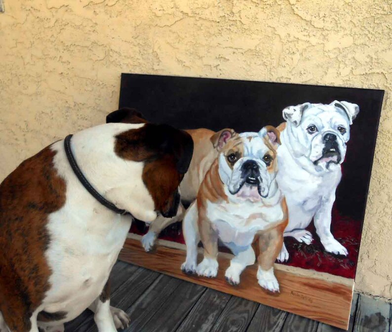 K&ouml;nnte beinhalten: Ein Gem&auml;lde von drei Bulldoggen, eine wei&szlig;e und zwei braun-wei&szlig;e, auf einem roten Teppich vor einem schwarzen Hintergrund. Ein vierter Hund, ein Boxer, ist im Vordergrund und betrachtet das Gem&auml;lde. Das Gem&auml;lde befindet sich auf einem Holzrahmen.