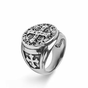 May include: A silver ring with a detailed design featuring a cross and the words "S.P.Q.R.  INRI  V.R.S.  N.S.  I.H.S.  M.S.S.  D.O.M.  P.P.  C.S.  P.X.  A.V.S.  P.R.A.Y.  F.E.A.R.  N.O.T.  S.O.N.  O.F.  G.O.D.  L.W.S.  B.M.S.  D.C.S.  C.P.S.  S.C.S.  S.P.Q.R."