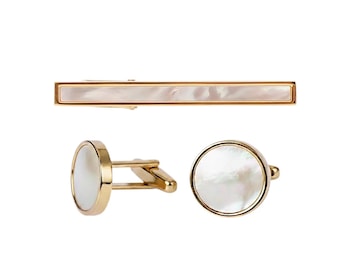 May include: A gold-toned tie bar and a pair of cufflinks with a mother-of-pearl inlay. The cufflinks have a circular design, while the tie bar is rectangular. The set is displayed on a white background.