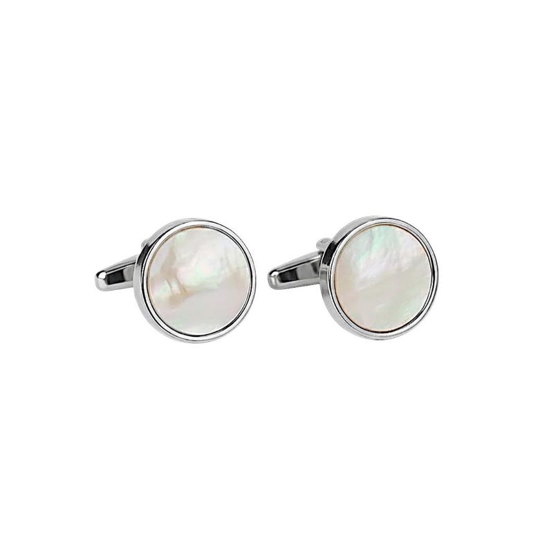 May include: A pair of silver cufflinks with a round, iridescent mother-of-pearl center. The cufflinks have a polished, reflective finish and a classic design, suitable for formal wear.