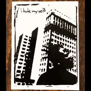 May include: Black and white graphic print of a building with the text "i hate myself" written above it.