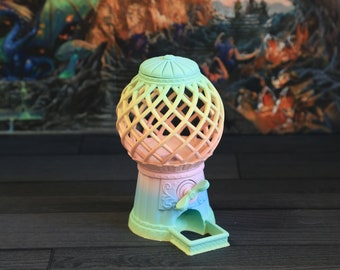 May include: A pastel-colored gumball machine with a lattice-style globe and a crank on the side. The machine is painted in a gradient of green, yellow, and pink.