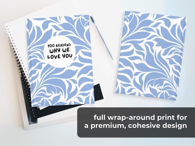 May include: A blue and white patterned journal with the text "100 Reasons Why We Love You" in a white circle. The journal has a full wrap-around print for a premium, cohesive design.
