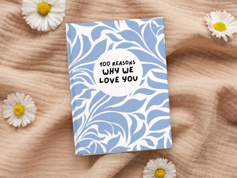 May include: A blue and white journal with a floral pattern and the text "100 Reasons Why We Love You" in a circle.