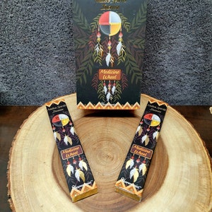 May include: A box of Native Spirits Incense with a Medicine Wheel design. The box is black with gold lettering and a colorful Medicine Wheel design. The incense sticks are also black with gold lettering and a Medicine Wheel design. The incense sticks are labeled "Medicine Wheel" and "Harmonia".