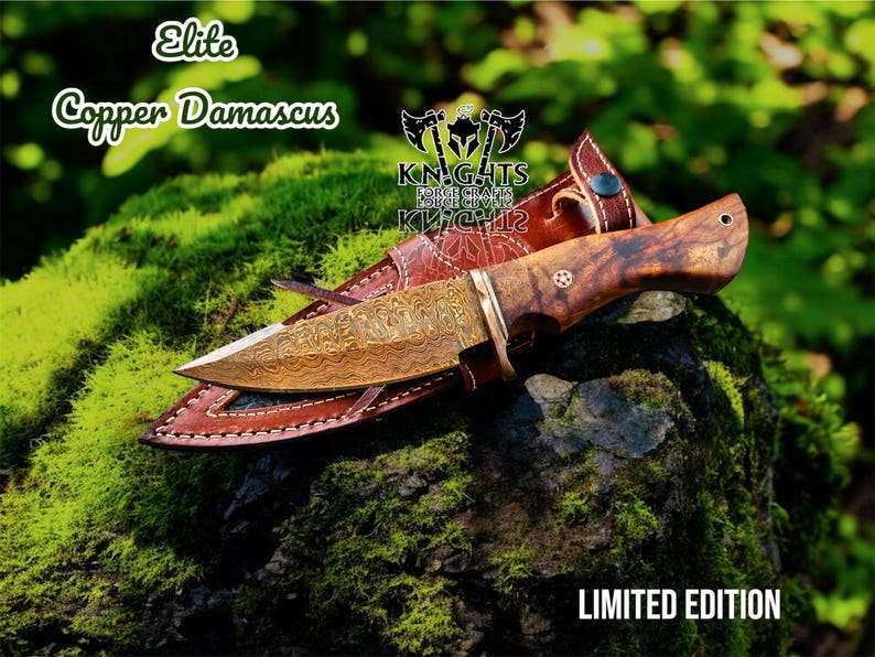 Puede incluir: Un cuchillo de cobre de Damasco con mango de madera y funda de cuero. La hoja tiene un patr&oacute;n intrincado. El cuchillo est&aacute; etiquetado como "Elite Copper Damascus" y "Limited Edition". La funda es marr&oacute;n.