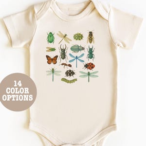 May include: A cream-coloured baby onesie with a colourful print of various insects, including butterflies, ladybugs and dragonflies.