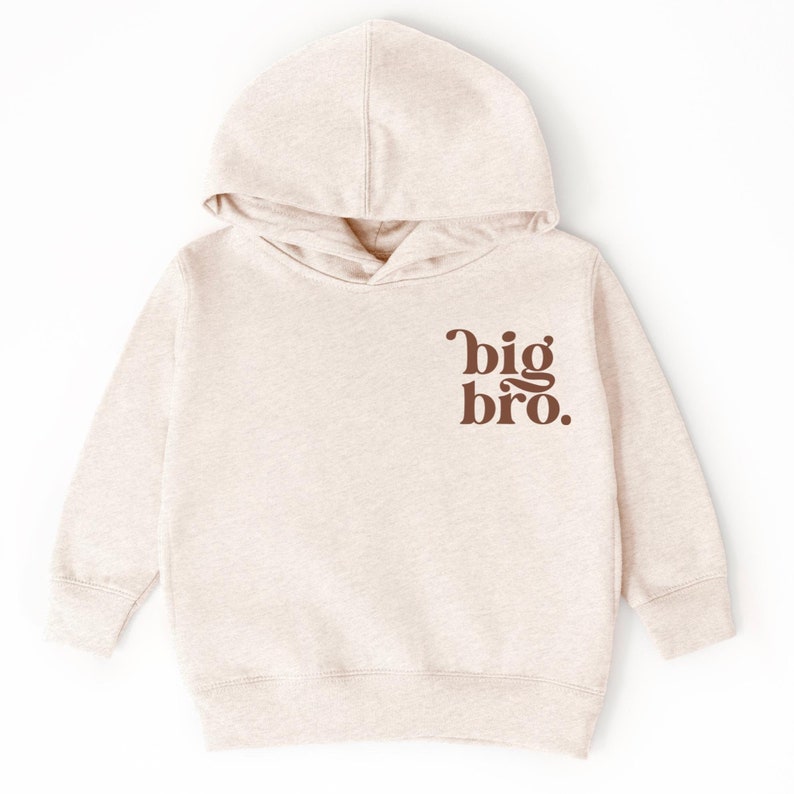 May include: A beige hooded sweatshirt with the text "big bro." printed in brown on the front.
