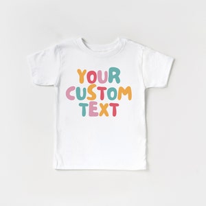 May include: White t-shirt with the text "YOUR CUSTOM TEXT" in colorful, bubble-like letters.
