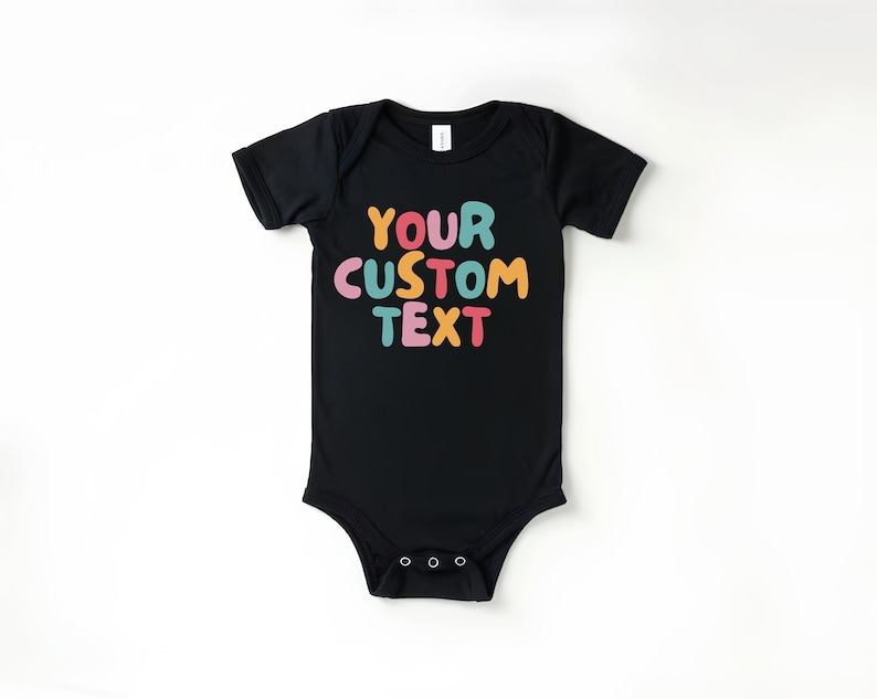 May include: Black baby onesie with short sleeves and a colorful text graphic that says "YOUR CUSTOM TEXT".