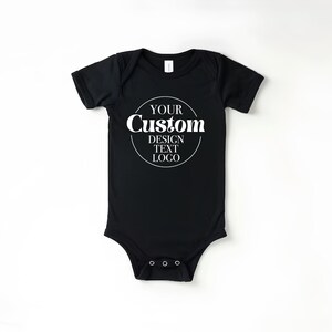 Op de afbeelding: Zwarte baby romper met witte tekst die "YOUR Custom DESIGN TEXT LOGO" in een cirkel weergeeft.