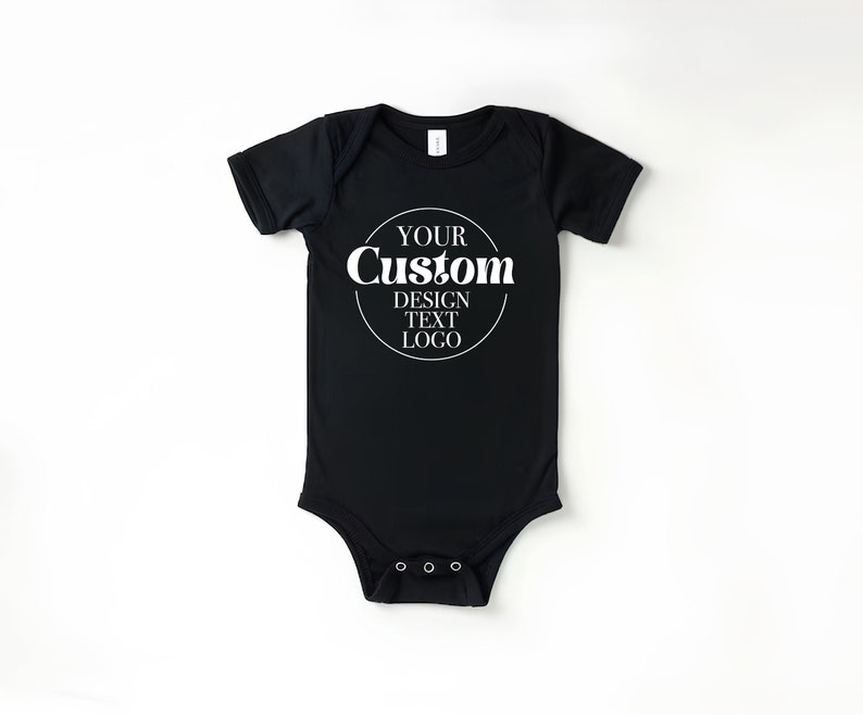 Op de afbeelding: Zwarte baby romper met witte tekst die "YOUR Custom DESIGN TEXT LOGO" in een cirkel weergeeft.