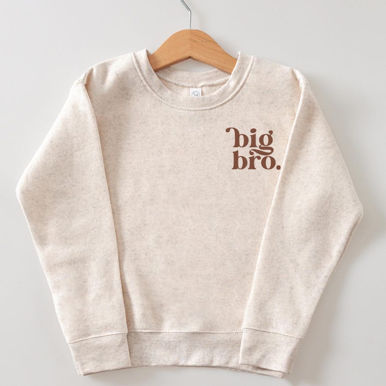 May include: A cream-colored sweatshirt with a brown graphic that says "big bro."