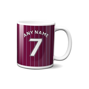 May include: White ceramic mug with a burgundy and white striped design. The mug has the text "ANY NAME" and the number "7" printed on it.