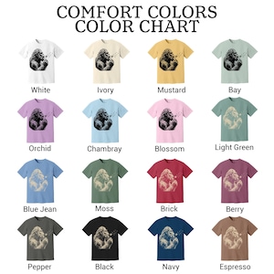 Puede incluir: Una carta de colores Comfort Colors con diecis&eacute;is camisetas de manga corta en varios colores, cada una con el gr&aacute;fico de una criatura soplando un diente de le&oacute;n. Los colores incluyen blanco, marfil, mostaza, bay, orqu&iacute;dea, chambray, flor, verde claro, azul jean, musgo, ladrillo, baya, pimienta, negro, marino y espresso.