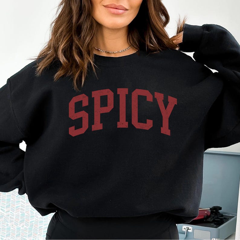 May include: Black sweatshirt with a red "SPICY" graphic printed on the front.