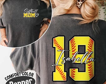May include: A gray t-shirt with the text "Softball Mom" and a heart on the front. The back of the shirt has a yellow softball with red stitching and the number 19 with the name "Isabella" written on it.