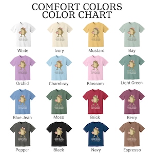 May include: A Comfort Colors color chart featuring sixteen short-sleeve t-shirts in various colors. Each shirt displays a graphic of a frog wearing a pink bow and holding a mug, with the text: First of all, Jesus thinks I'm a delight.