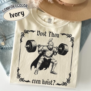 Może przedstawiać: Kremowa bluza Comfort Colors z czarną grafiką przedstawiającą rycerza podnoszącego sztangę. Tekst "Dost Thou even hoist?" jest wydrukowany nad i pod ilustracją. Bluza ma okrągły dekolt i długie rękawy.