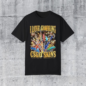 May include: Black t-shirt with a graphic design of a variety of colorful guns and the text "I love gambling CSGO skins".