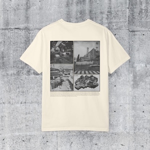 May include: Cream-colored t-shirt featuring a black and white collage of architectural images. The design includes four panels with various scenes, and Japanese text. A small line of text is printed below the collage.